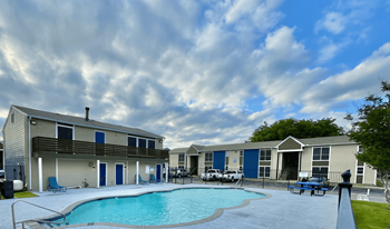 Pool area with apartment buildings and lounge chairs